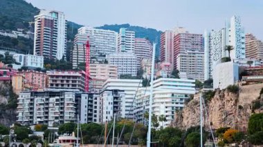 Monaco Marina 'ya kenetlenmiş teknelerin görüntüsü ve arka planda şehrin silüeti.