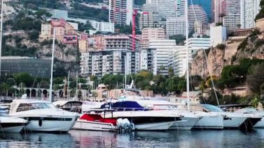 Monaco Marina 'ya kenetlenmiş teknelerin görüntüsü ve arka planda şehrin silüeti.