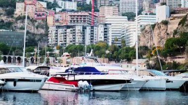Monaco Marina 'ya kenetlenmiş teknelerin görüntüsü ve arka planda şehrin silüeti.