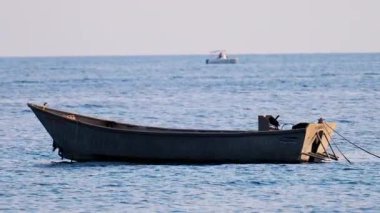 Kara tekne bulutlu bir günde denize yanaştı.
