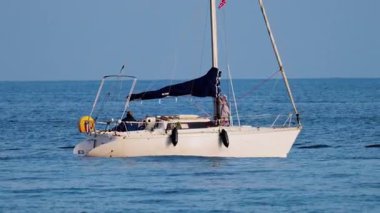 Antibes, Fransa - 14 Şubat 2025 Bulutlu bir günde yüzen bir teknede adam
