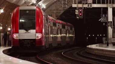 Monte Carlo, Monako - 5 Ocak 2025: İnsanlar ve trenler Monako tren istasyonunda parlak ışıklarla ilerliyorlar