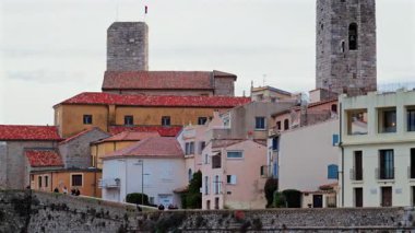 Antibes, Fransa - 20 Şubat 2025: Sahildeki farklı binaların etrafında yürüyen insanların görüntüsü