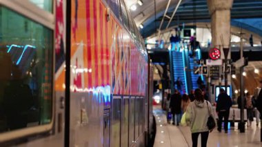 Monte Carlo, Monako - 20 Şubat 2025: İnsanlar ve trenler Monako tren istasyonunda parlak ışıklarla hareket ediyor
