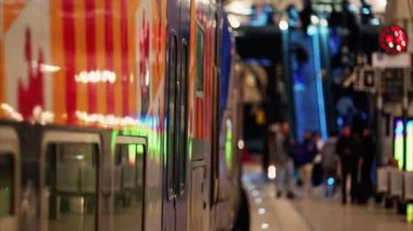 Monte Carlo, Monako - 20 Şubat 2025: İnsanlar ve trenler Monako tren istasyonunda parlak ışıklarla hareket ediyor