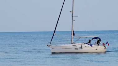 Antibes, Fransa - 14 Şubat 2025: Bulutlu bir günde Fransa bayrağıyla denizde hareket eden tekne