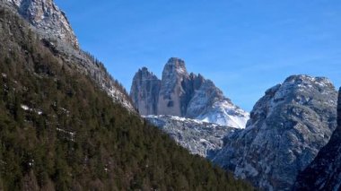 Arkadaki bulutlu gökyüzü ile Dolomitler, İtalya 'daki ağaçların ve dağların üzerindeki kar manzarası