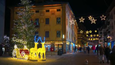 Cortina d 'Ampezzo, İtalya - 10 Ocak 2025: İnsanlar akşamları Noel pazarında yürüyorlar