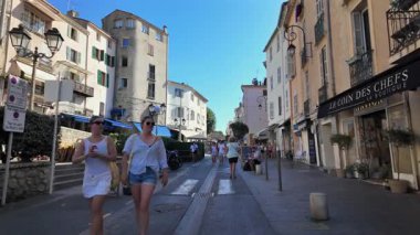 Antibes, Fransa - 13 Ağustos 2024: Güneşli bir günde insanlar şehrin sokaklarında yürüyor