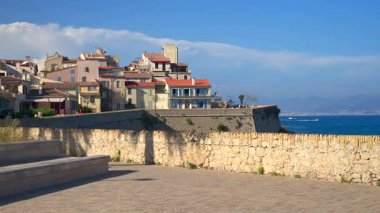 Antibes, Fransa sahillerindeki farklı binaların etrafında yürüyen insanların görüntüsü