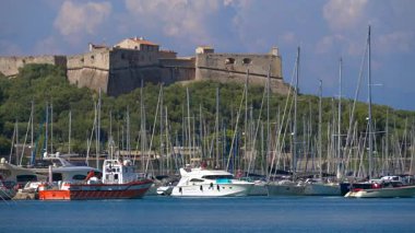 Antibes, Fransa - 13 Ağustos 2024: Arka planda Fort Carre ile Vauban Limanı 'ndan geçen tekneler