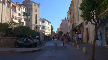 Antibes, Fransa - 13 Ağustos 2024: Güneşli bir günde insanlar şehrin sokaklarında yürüyor