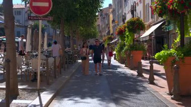 Antibes, Fransa - 13 Ağustos 2024: Güneşli bir günde insanlar şehrin sokaklarında yürüyor