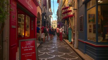 Antibes, Fransa - 13 Ağustos 2024: Güneşli bir günde insanlar şehrin sokaklarında yürüyor