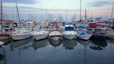 Cannes, Fransa - 15 Ağustos 2024: Bir tekne dolusu insan gün batımında Cannes Limanı 'na yanaştı.