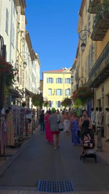 Antibes, Fransa - 20 Ekim 2024: Güneşli bir günde insanlar şehrin sokaklarında yürüyor. Dikey