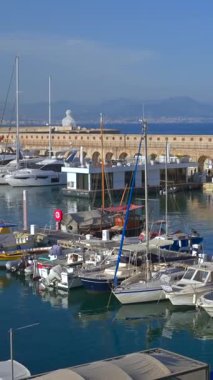 Antibes, Fransa - 20 Temmuz 2024: Denizde yüzen ve plajda dinlenen insanları görmek. Dikey