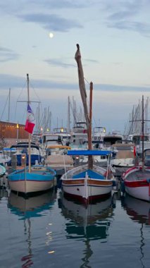 Cannes, Fransa - 15 Temmuz 2024: beyaz tekneler gün batımında Port de Cannes 'a yanaştı. Dikey