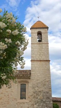 Chapelle des Conitents Blancs Kilisesi 'nin yanında yürüyen insanlar manzarası. Dikey, Saint Paul de Vence, Fransa