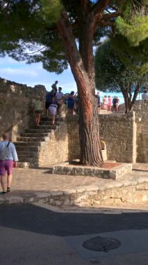 Saint Paul de Vence, Fransa - 10 Ağustos 2024: İnsanlar şehrin kaldırımlı sokaklarında yürüyor. Dikey