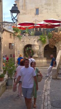Saint Paul de Vence, Fransa - 10 Ağustos 2024: İnsanlar şehrin kaldırımlı sokaklarında yürüyor. Dikey
