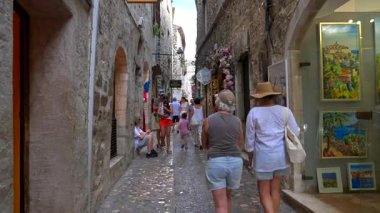 Saint Paul de Vence, Fransa - 10 Ağustos 2024: Şehrin kaldırım taşlı sokaklarında yürüyen insanlar