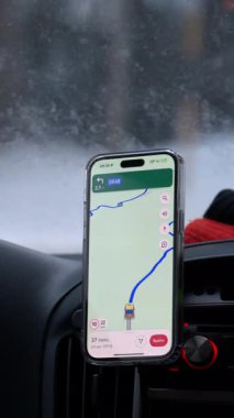 Dolomitler, İtalya - 15 Ocak 2025: Dolomitler 'in dağlarında karda giden ve Google Maps' i gösteren bir akıllı telefona yakından bakın. Dikey