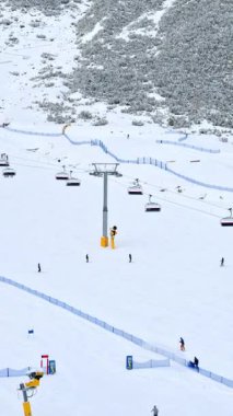 Dolomitler, İtalya - 15 Ocak 2025: Kayak merkezinin yakınındaki bir kayak merkezindeki insanların uzak görüntüsü. Dikey