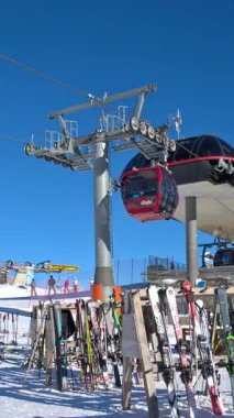 Dolomitler, İtalya - 15 Ocak 2025: Arka planda dağlarla birlikte hareket eden kırmızı kayak asansörlerinin hava manzarası. Dikey