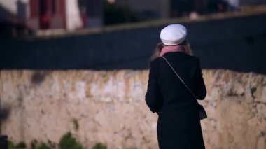 Cannes, Fransa 'da sokakta yürürken palto giyen bir kadın.