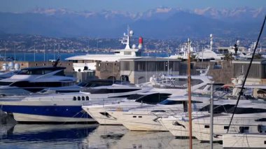 Cannes, Fransa - 3 Mart 2025: Tekneler Cannes Marina 'da arka planda dağlarla kenetlendi