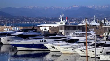 Cannes, Fransa - 3 Mart 2025: Tekneler Cannes Marina 'da arka planda dağlarla kenetlendi
