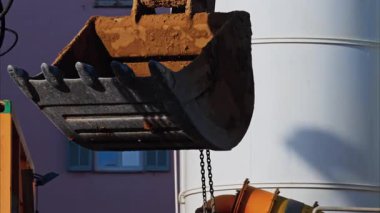 Bir inşaat alanında hareket eden ve kaldıran sarı bir vinç makinesini kapat