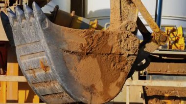 Bir inşaat alanında hareket eden ve kaldıran sarı bir vinç makinesini kapat