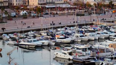 Cannes, Fransa - 15 Mart 2025: Cannes Marina 'da arka planda şehir binaları bulunan birden fazla teknenin görüntüsü