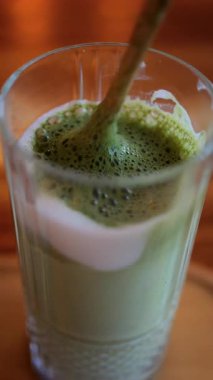 Kafedeki bir masada, bir kibrit sütlü kahveye karıştırılmış kaşığı kapat. Dikey