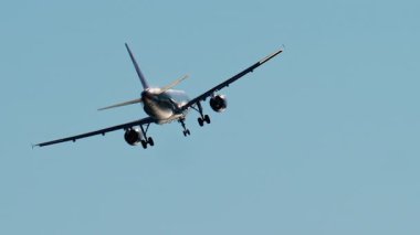 Gün ışığında mavi gökyüzünde uçan uçak