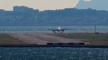 Arka planda binalar olan Nice Havaalanı 'na inen bir uçak görüntüsü.