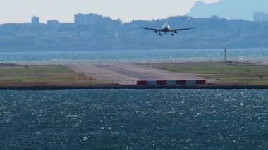 Arka planda binalar olan Nice Havaalanı 'na inen bir uçak görüntüsü.