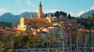 Menton, Fransa - 18 Mart 2025: St. Michel Bazilikası 'nın renkli binalarla çevrili uzak manzarası