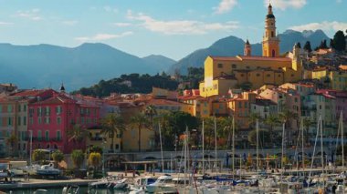 Menton, Fransa - 18 Mart 2025: St. Michel Bazilikası 'nın renkli binalarla çevrili uzak manzarası