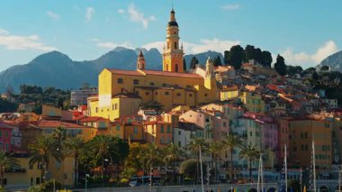 Menton, Fransa - 18 Mart 2025: St. Michel Bazilikası 'nın renkli binalarla çevrili uzak manzarası