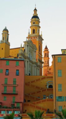 Menton, Fransa - 18 Mart 2025: renkli binalarla çevrili St. Michel Bazilikası manzarası. Dikey