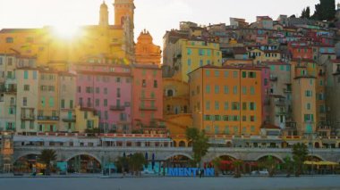 Menton, Fransa - 18 Mart 2025: Mavi Menton tabelasının altında şehrin renkli binaları var