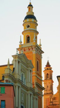 Menton, Fransa - 18 Mart 2025: renkli binalarla çevrili St. Michel Bazilikası manzarası. Dikey