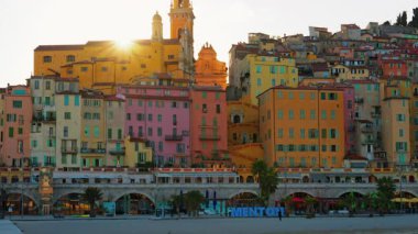 Menton, Fransa - 18 Mart 2025: Mavi Menton tabelasının altında şehrin renkli binaları var