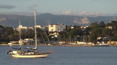 Antibes, Fransa - 21 Mart 2025: Tekne arka planda şehirle birlikte denize yanaştı