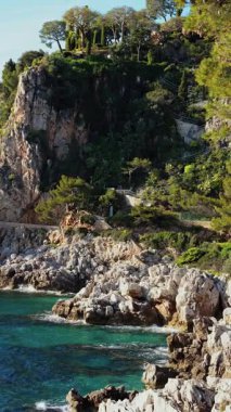 Saint-Jean-Cap-Ferrat, Fransa 'da deniz kıyısında bir uçurum manzarası. Dikey