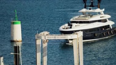 Cannes, Fransa - 16 Mart 2025: Güneşli bir günde Vieux-Port yakınlarında denizde hareket eden beyaz bir tekne