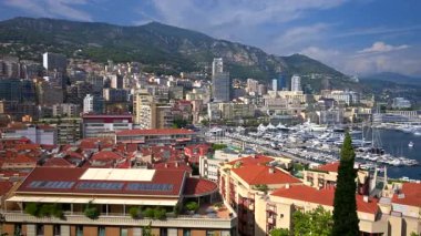 Monaco Marina 'ya kenetlenmiş teknelerin görüntüsü ve arka planda şehrin silüeti.